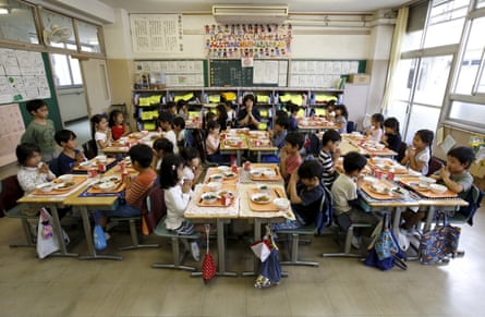 First grade students eat lunch at their desks in their classroom