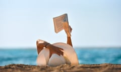 Young woman reads a book on the beach