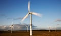 Wind turbines spinning in a wide flat field