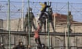 Migrants climb the fences separating the Spanish enclave of Melilla from Morocco as police and border forces armed with truncheons stand on the other side