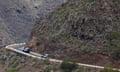 Police vehicles parked on a road in rocky terrain