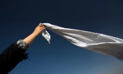 Woman raises her Palestinian scarf