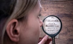 Curator Sarah Laycock uses a magnifying glass to inspect the miniature manuscript.