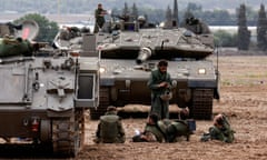 Israeli soldiers gather near tanks