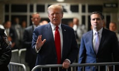 Man in red tie and suit stands next to crush barrier