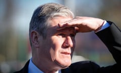 Keir Starmer, looking serious, shades his eyes with one hand.