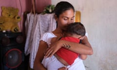 Single mother Anne Roshel holds her nine-month-old baby son who was underweight at birth. Keeping him well fed is a daily struggle.