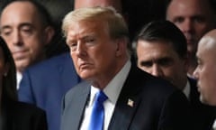 white man wearing black suit and blue tie surrounded by people