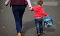 A mother and child walk up a street.