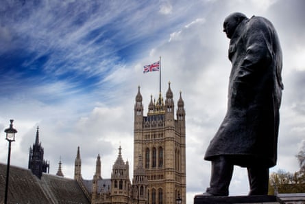Houses of Parliament flying a Union Jack flag and statue of Winston Churchill in foreground