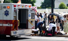Emergency workers help an elderly man who fainted during a heat wave