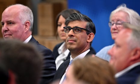 Rishi Sunak sitting in a crowd of people