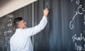 University lecturer writing on a blackboard