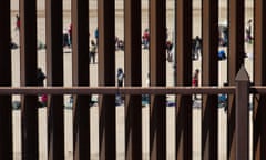 Migrants waiting along the border wall to surrender to US Customs and Border Protection (CBP) border patrol agents after crossing the Rio Grande River into the US, on the US-Mexico border in El Paso, Texas, on May 11, 2023. 