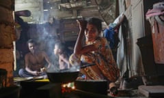 A woman sits by the fireplace at meal time in a shanty in Colombo, Sri Lanka