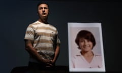 Walter Denton, 55, stands behind a photo of himself when he was about 12 years old, in Hagatna, Guam, in May 2019.