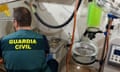 Guardia Civil officer kneeling in front of lab equipment