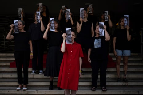 Relatives and supporters of Israeli hostages held by Hamas in Gaza hold photos of their loved ones during a performance calling for their return, in Tel Aviv on Thursday.