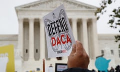 A hand holds up a sign that says "Defend Daca" as people rally outside the supreme court in Washington.