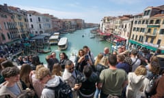 Tourists take photographs on the Rialto Bridge in Venice