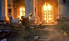 A protester throws a petrol bomb at the Trade Union building in Odessa