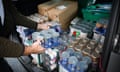 A volunteer loads up a car at a food bank distribution hub.