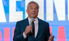 A man in a blue suit who is Robert F Kennedy Jr speaks into a microphone