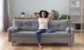 Calm black woman relaxing on comfortable sofa in living room<br>Young calm black woman relaxing sit on comfortable sofa in modern living room, lazy happy african woman girl resting on couch breathing fresh air enjoy peace of mind no stress free on couch at home