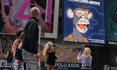 People take photos by a Bored Ape Yacht Club NFT billboard in Times Square in New York City.