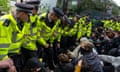 Police officers prepare to move protesters surrounding a bus that was to be used to carry migrants from a hotel in Peckham, London, earlier this month.