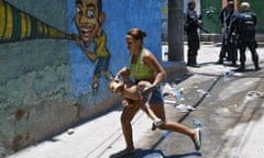 A resident flees during a raid in the Alemão favela complex, where shootouts are common between gangs and the Police Pacifying Unit (UPP).