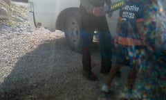 A guard scans a child outside Nauru detention centre.