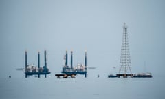 In a scene with the sky the same silver gray color as the water, towers appear to sit in the middle.