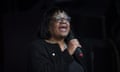 Diane Abbott speaks into a mic against a black background