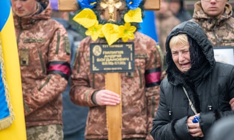 A mother cries near her son’s grave during the ceremony