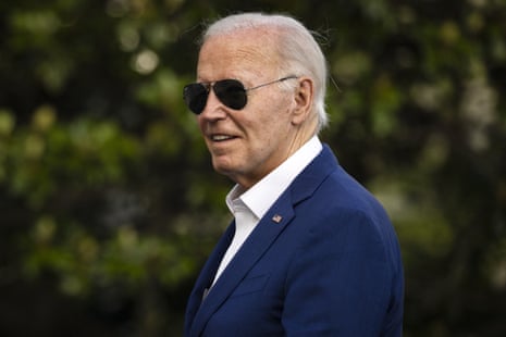 a man in a blue suit and sunglasses smiles