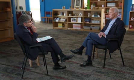 two men face to face in chairs in a school library