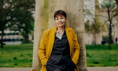 Portrait of Caroline Lucas standing with her back to a tall tree in Victoria Gardens, Brighton.