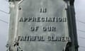 Large, vertical, stone (?) carving on the side of a pillar  that says 'In Appreciation of our Faithful Slaves'.