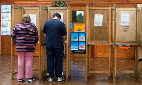 Two people in voting booths at a polling station