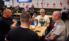 Four men sit around a table in a social club