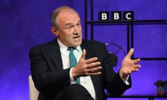 Ed Davey sits in chair in TV studio with BBC logo in background