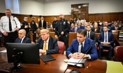 Small courtroom with table at front. People are mostly white men in suits.