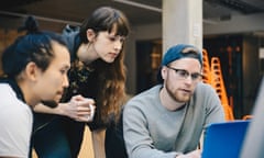 Computer programmers using laptop at a desk