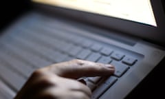 Man's hand typing on a laptop