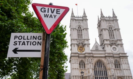 A polling station direction sign is attached to a street sign near to Westminster Abbey, ahead of general elections, in London, UK.