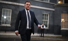 Mel Stride, in a suit and tie, walks across Downing Street at night