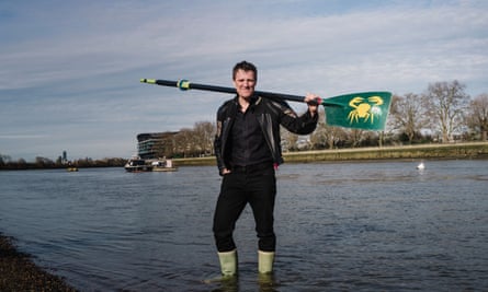 James Cracknell standing in the Thames in west London with an oar on his shoulders