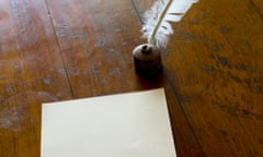 a quill pen beside a blank sheet of paper.