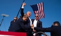 Former President Donald Trump is taken from the stage after the shooting.